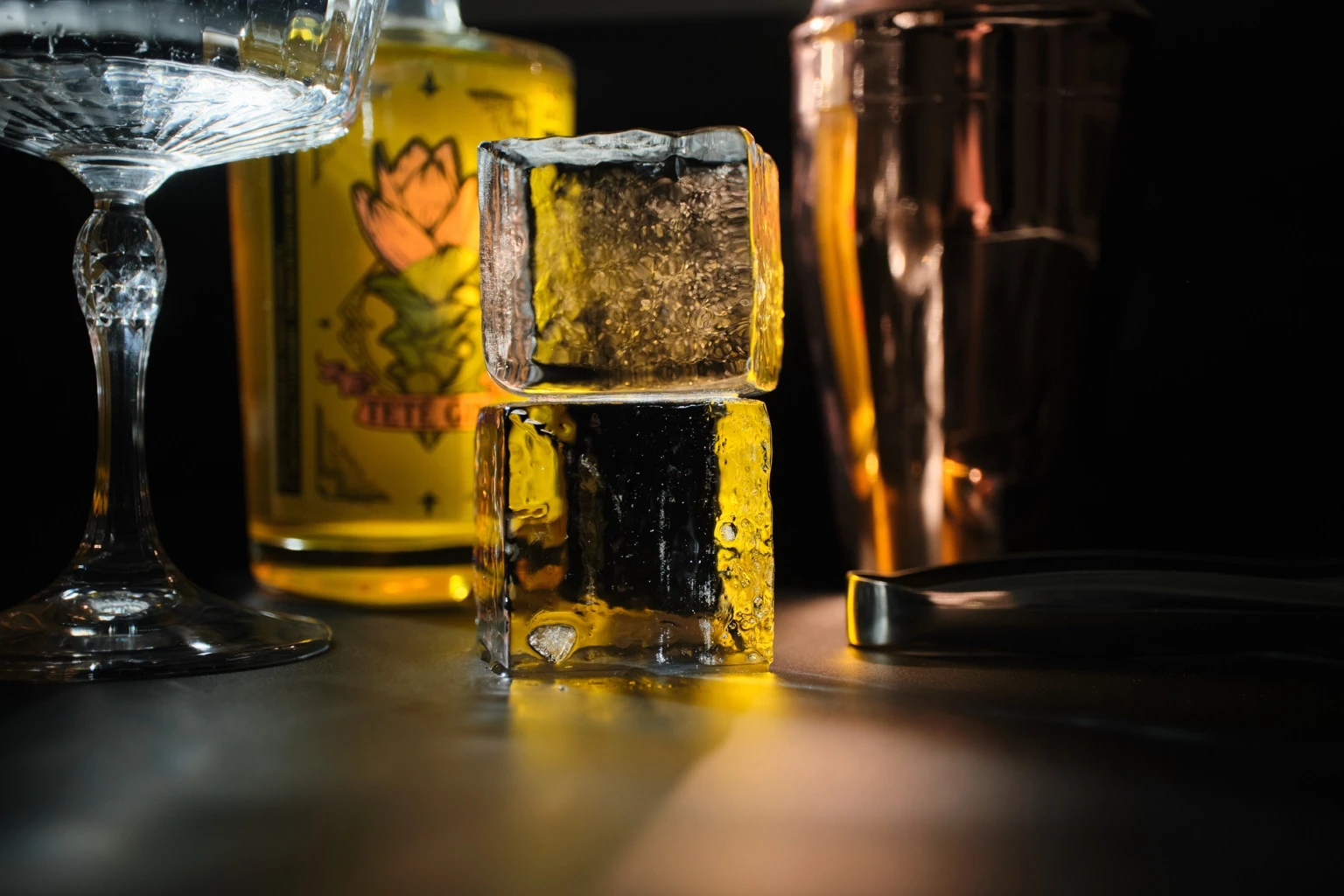 Gin Teté vertiéndose sobre hielo en un ambiente oscuro